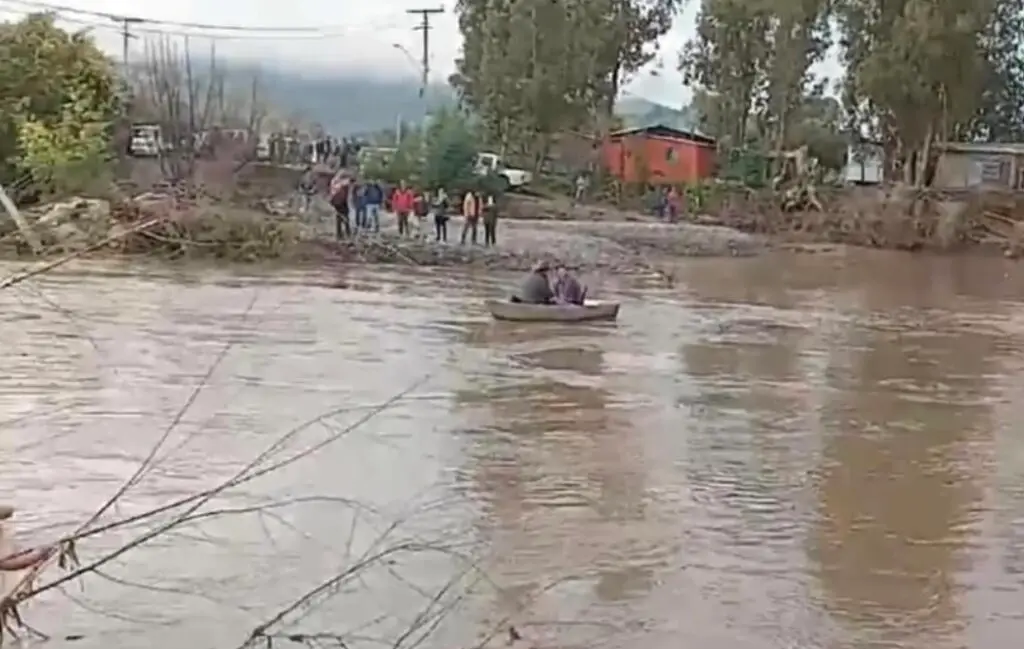 Vecinos de Villa Prat cruzan el río Mataquito en bote para llevar ayuda a La Huerta
